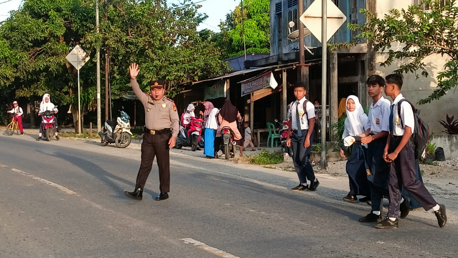 Kapolsek Kampar Turun Langsung Atur Arus Lalu Lintas Pagi dan Seberangkan Anak Sekolah