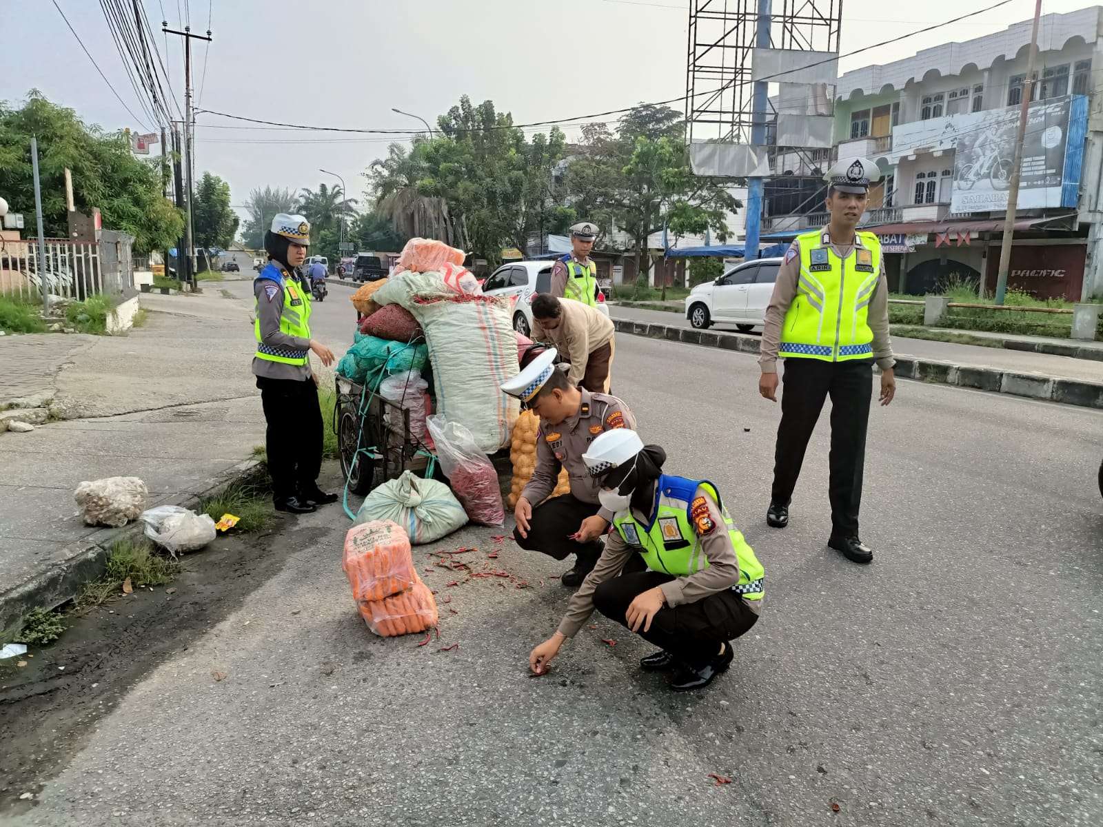 Respon Cepat,Kanit Lantas Polsek Senapelan Bantu Pungut Cabe Pedagang Yang Berserakan Di Jalan